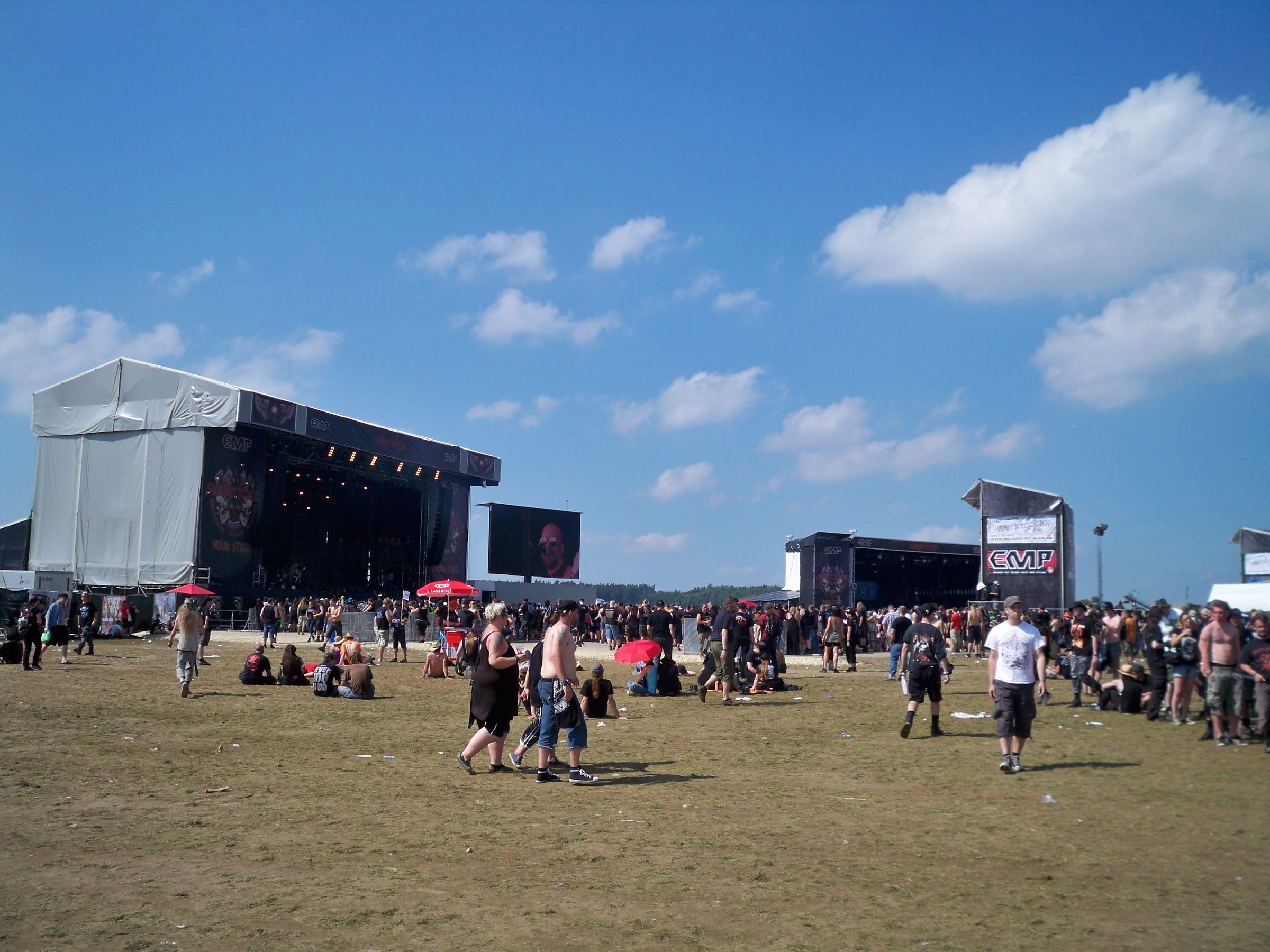 Festivalgelände mit zwei Bühnen, Publikum und blauem Himmel